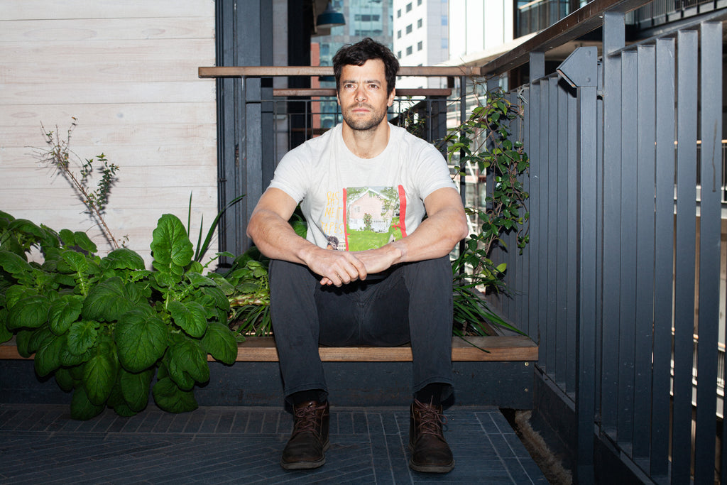 Modelo con polera de arte BIG PINK de Sergio Coddou. Versión color Dust, Classic Fit. Foto de estilo urbano.